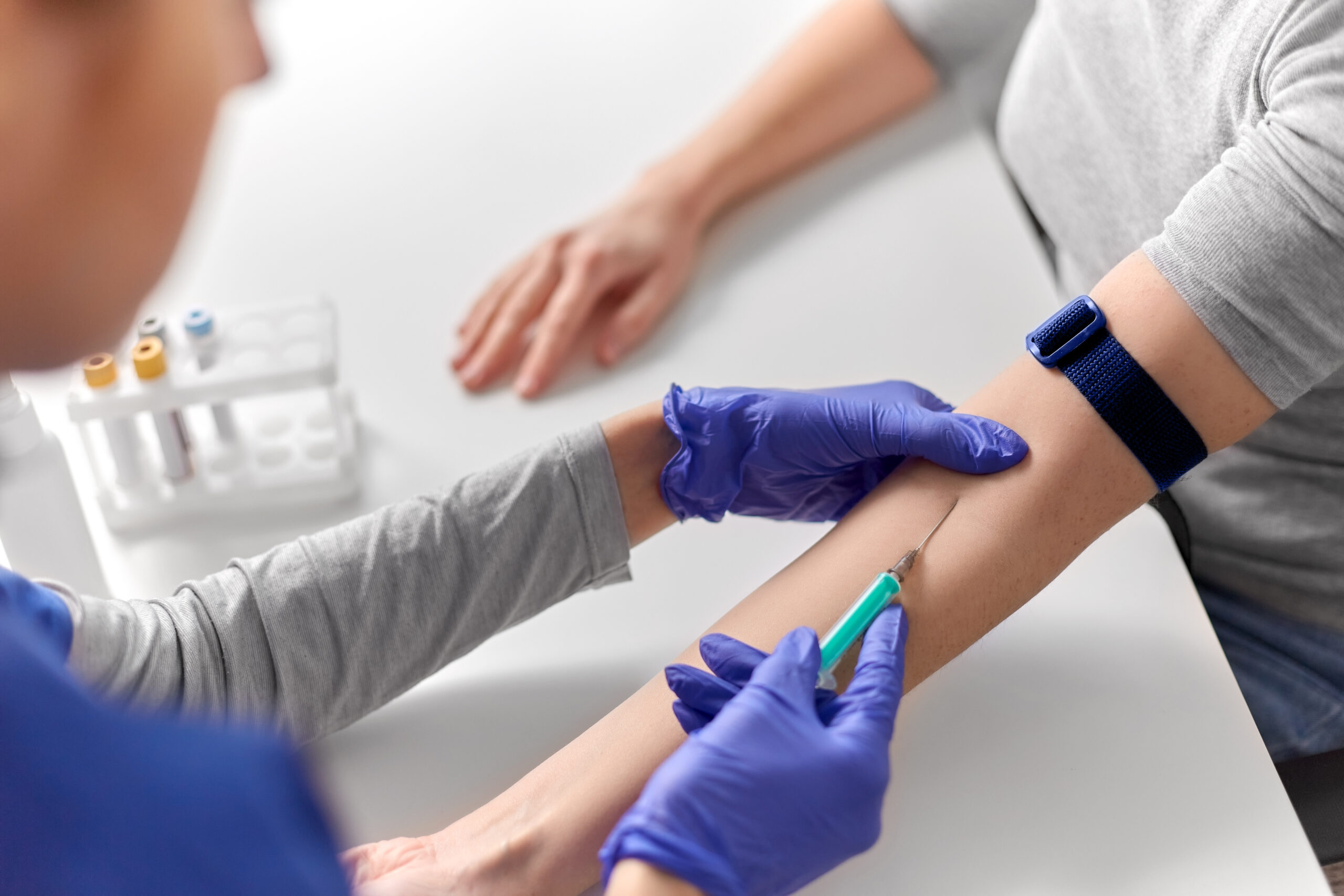 doctor taking blood for test from patient's hand